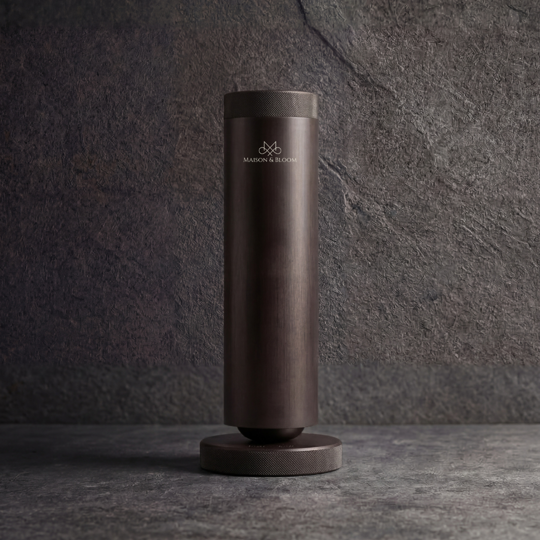 Matte black modern essential oil diffuser with cylindrical design on textured stone surface