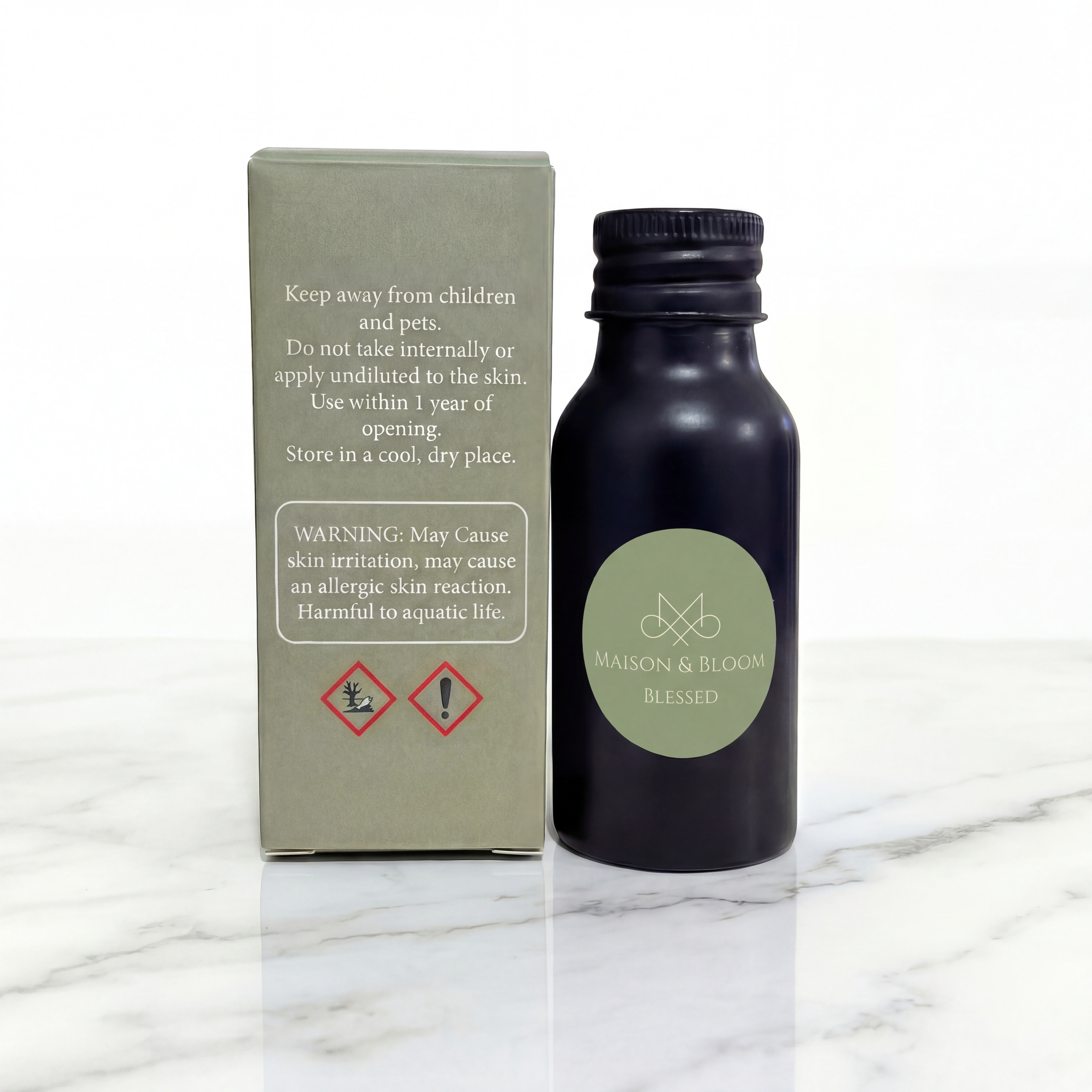 Essential oil bottle labeled 'Blessed' with safety warning box on marble surface