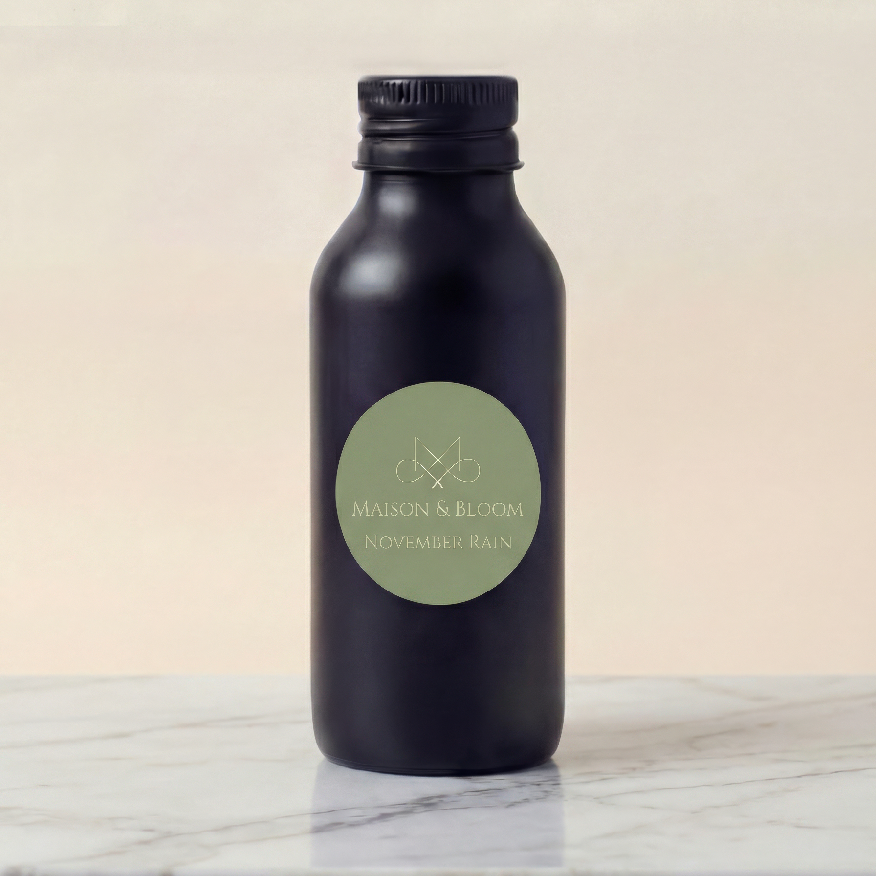 Matte black bottle labeled 'Maison & Bloom November Rain' on marble surface