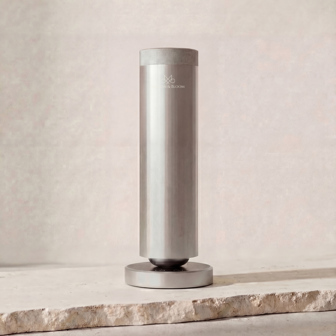 Modern silver essential oil diffuser with logo on stone surface, minimalist design