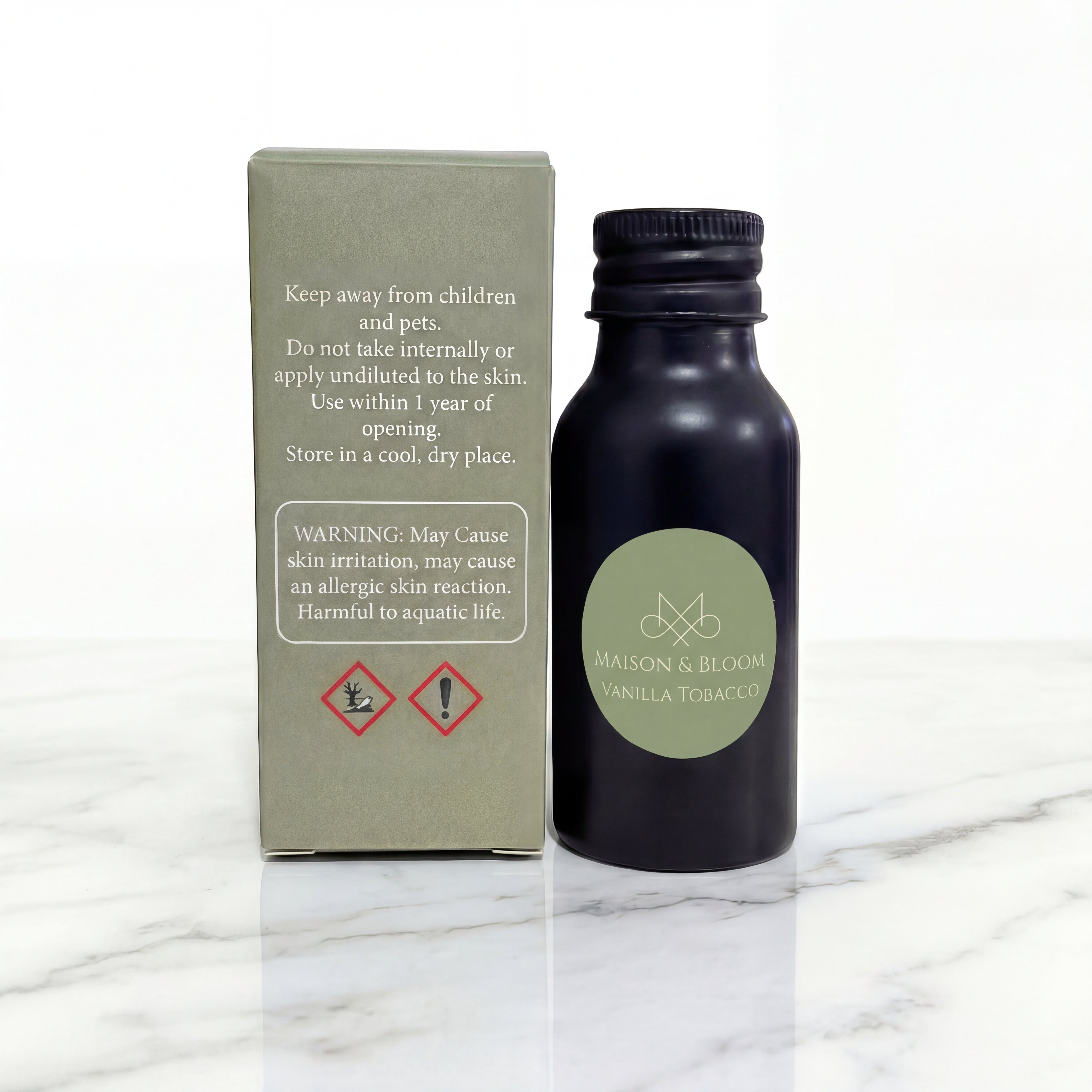 Vanilla Tobacco essential oil bottle with safety-labeled box on marble surface