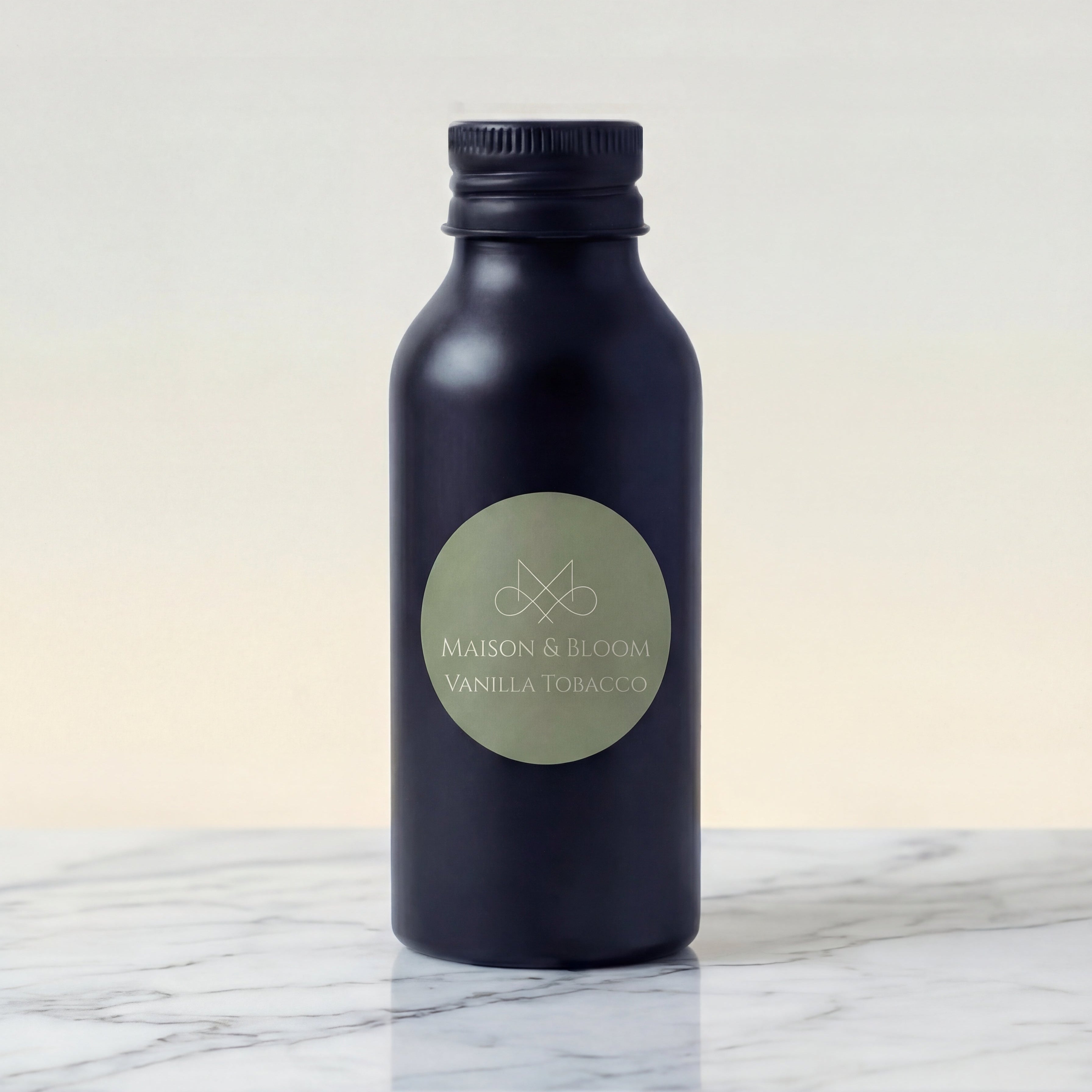 Matte black bottle labeled Vanilla Tobacco on marble surface, minimalist background