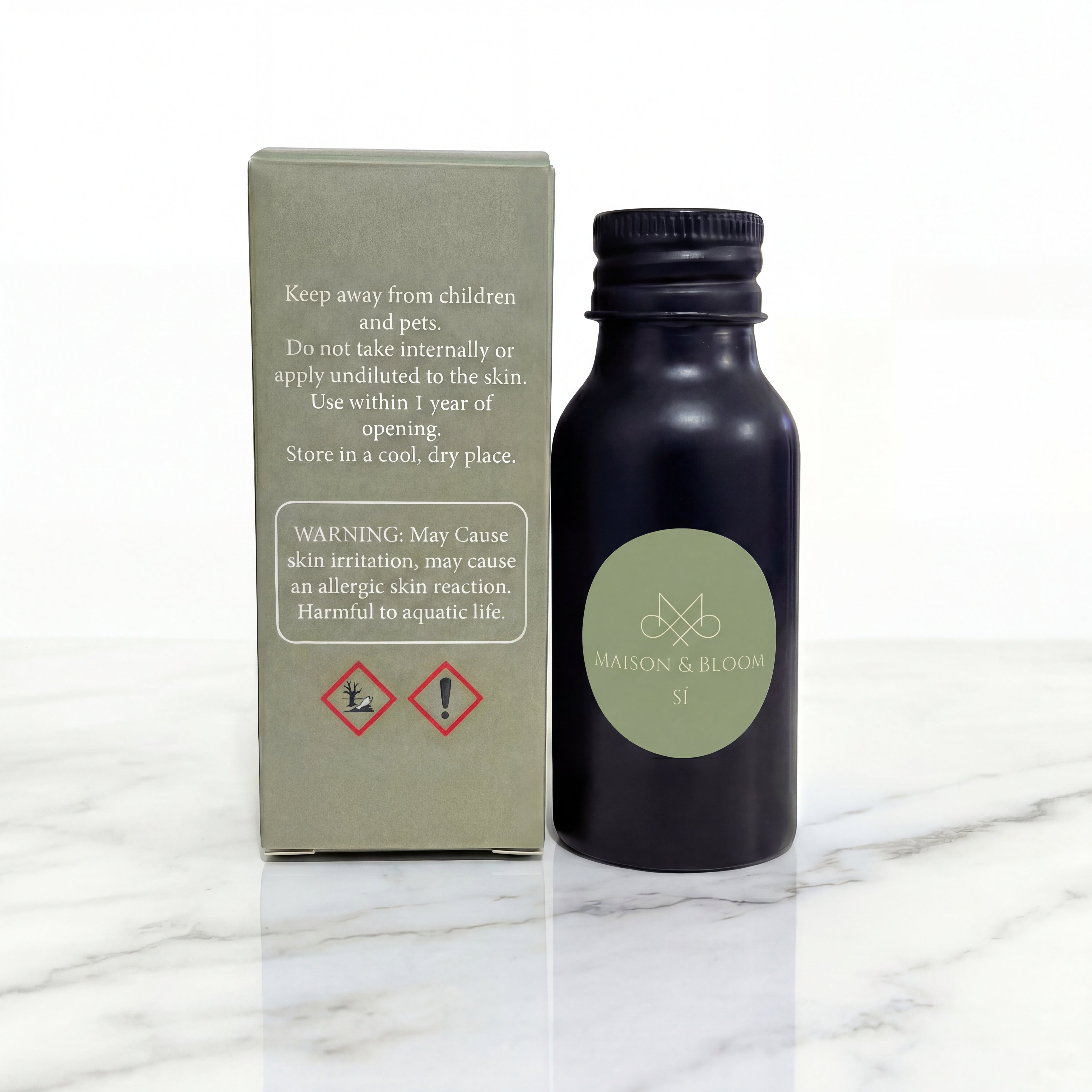 Botanical essential oil bottle labeled Si with packaging on marble surface